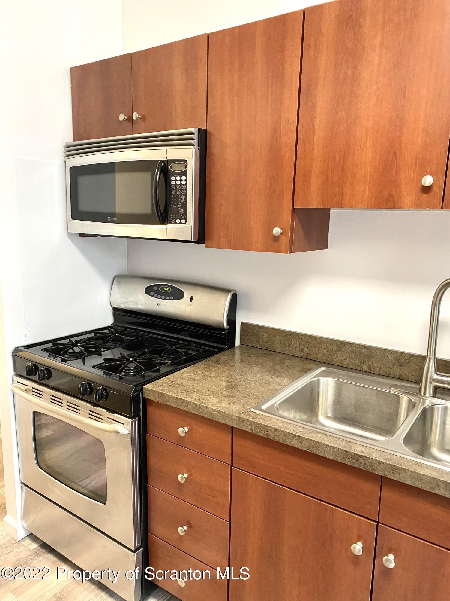 1111 Summit Pointe Scranton, PA 18508 - Photo 3 of 22 a kitchen with granite countertop a sink and a stove