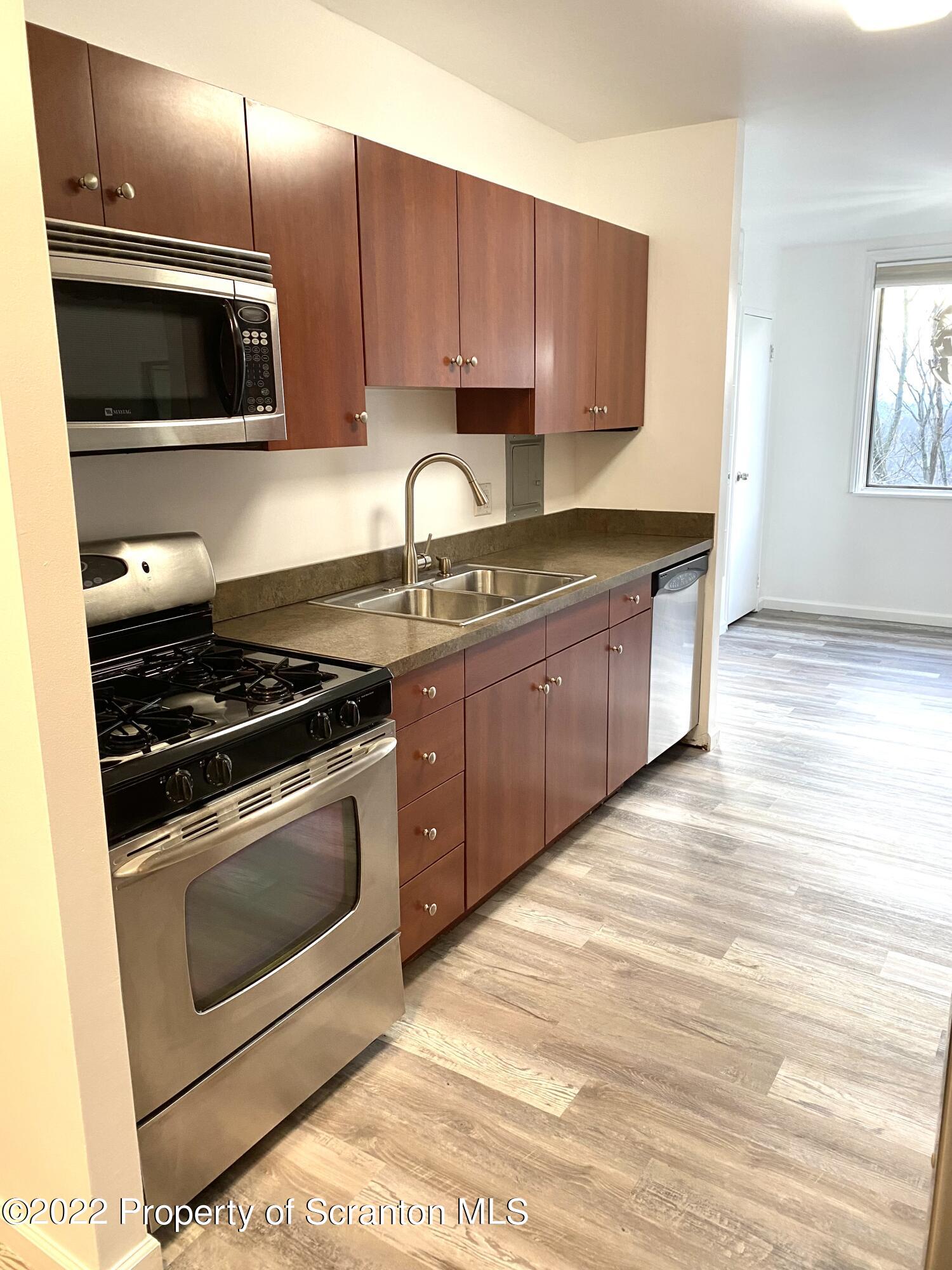 1111 Summit Pointe Scranton, PA 18508 - Photo 4 of 22 a kitchen with stainless steel appliances granite countertop a stove a microwave and a sink