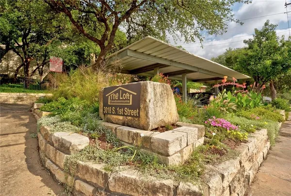 a view of an empty room with kitchen and a window