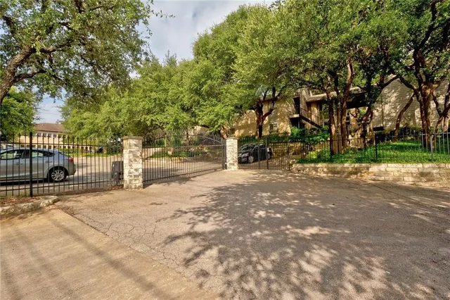 a view of a street with plants and large trees