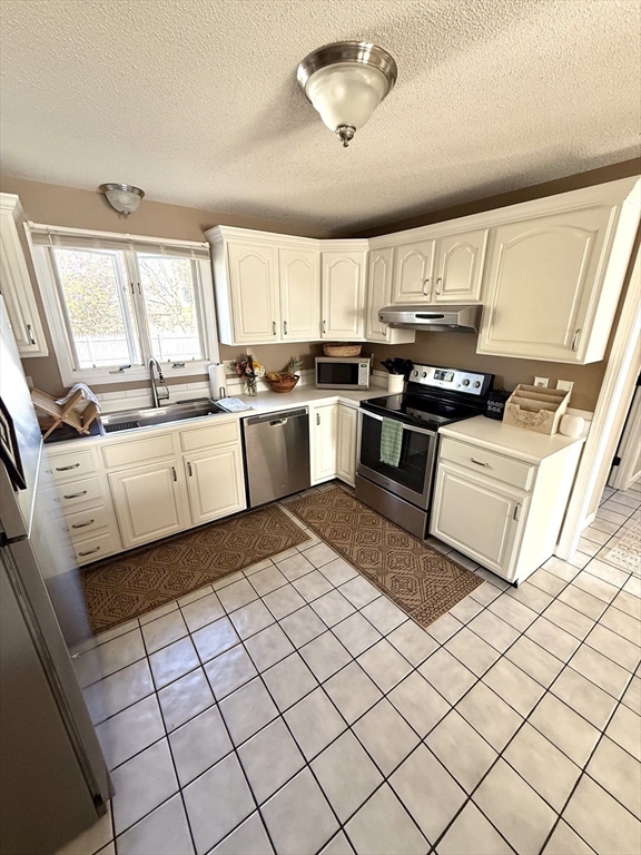59 Chalmers Street Springfield, MA 01118 - Photo 3 of 22 a kitchen with stainless steel appliances granite countertop a sink and white cabinets