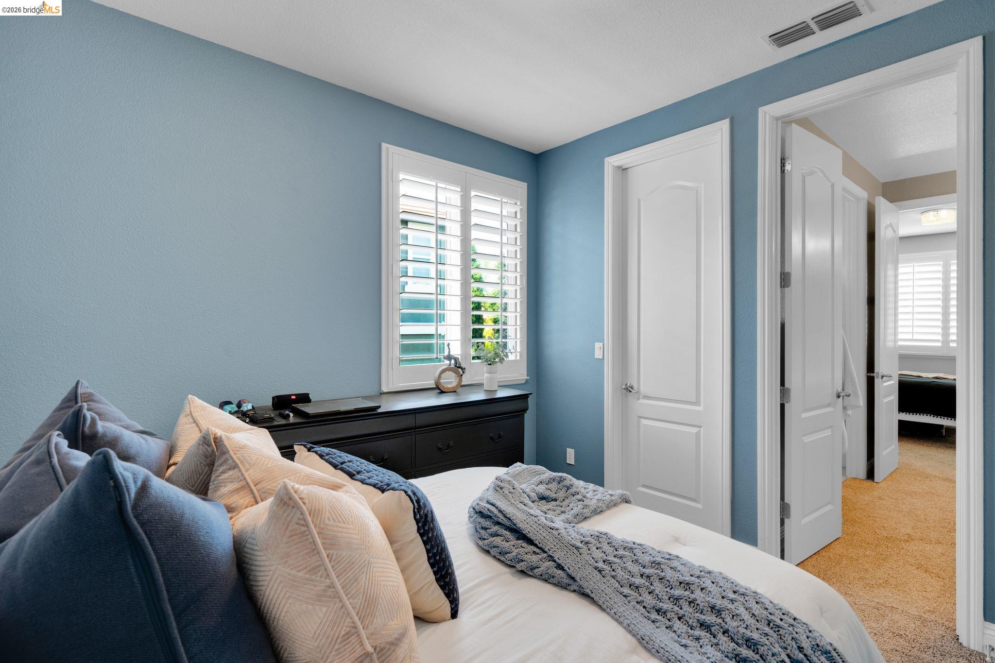 2513 Winged Foot Road Brentwood, CA 94513 - Photo 26 of 45 Bedroom featuring a window with white louvered shutters, light blue wall paint, and white trim