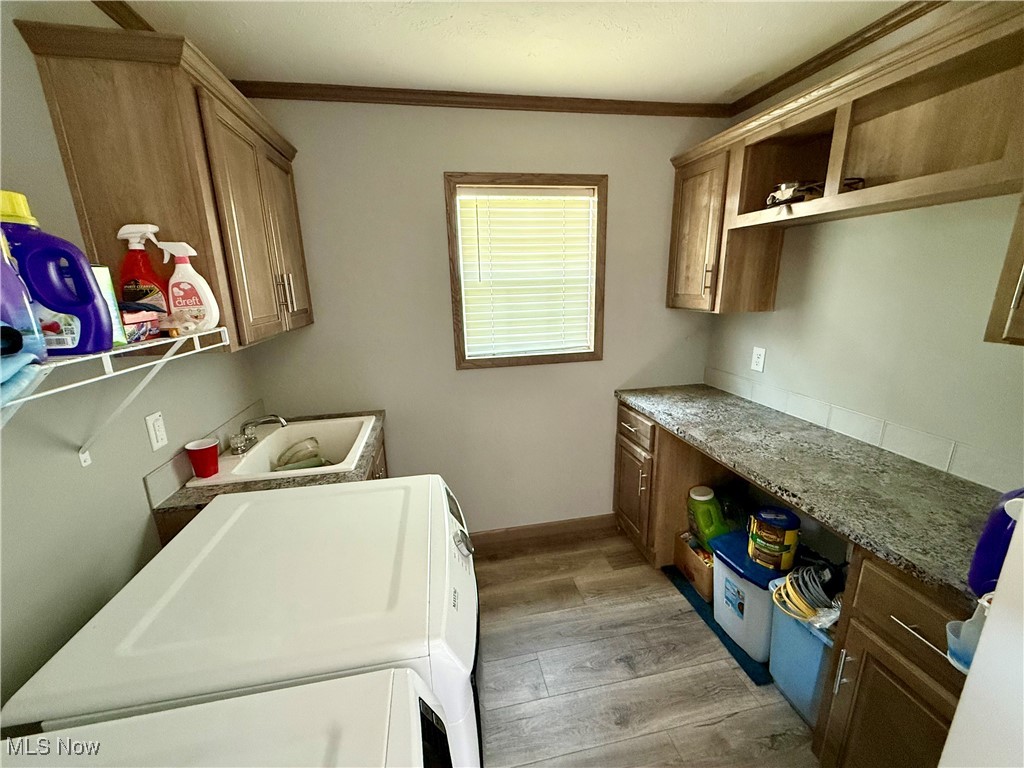 2306 Gordon Road Northwest Dover, OH 44622 - Photo 20 of 26 Laundry area with cabinet space, washing machine and dryer, light wood-style floors, and ornamental molding