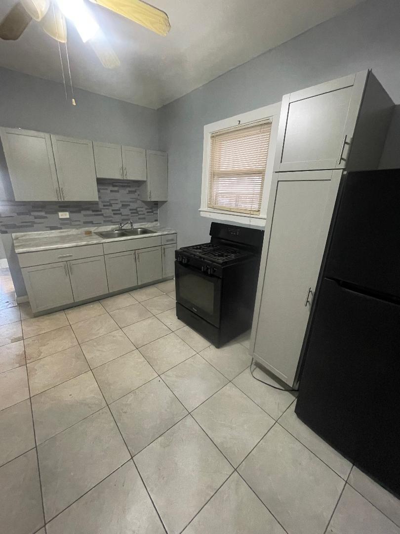 8136 South Exchange Avenue, Unit 2 Chicago, IL 60617 - Photo 4 of 8 a kitchen with a cabinets and a stove top oven