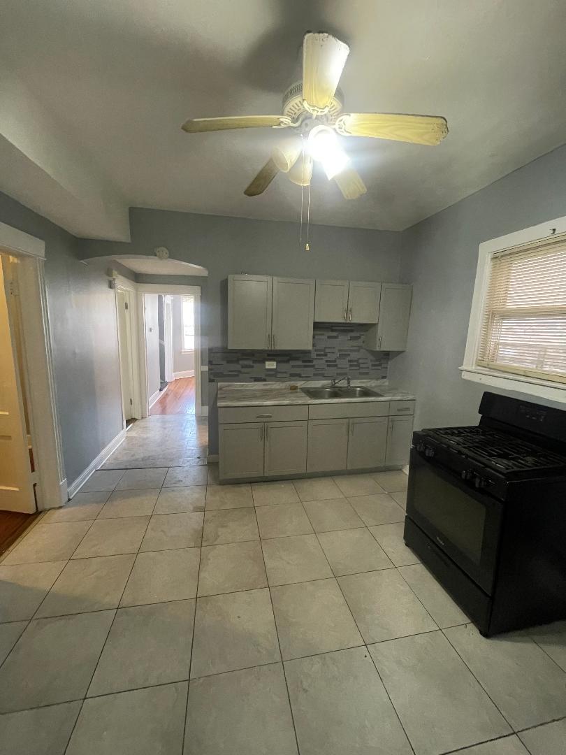 8136 South Exchange Avenue, Unit 2 Chicago, IL 60617 - Photo 5 of 8 a kitchen with a cabinets and appliances
