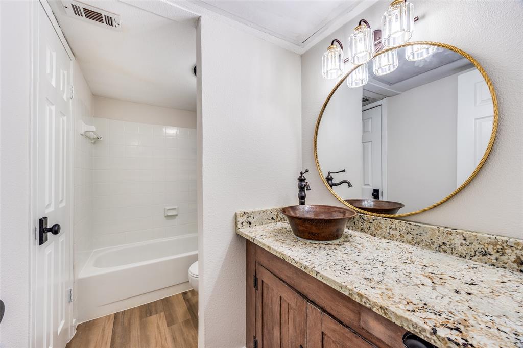 5300 Keller Springs Road, Unit 1067 Dallas, TX 75248 - Photo 12 of 14 a bathroom with a granite countertop sink a mirror and shower