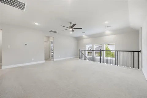an empty room with windows and ceiling fan