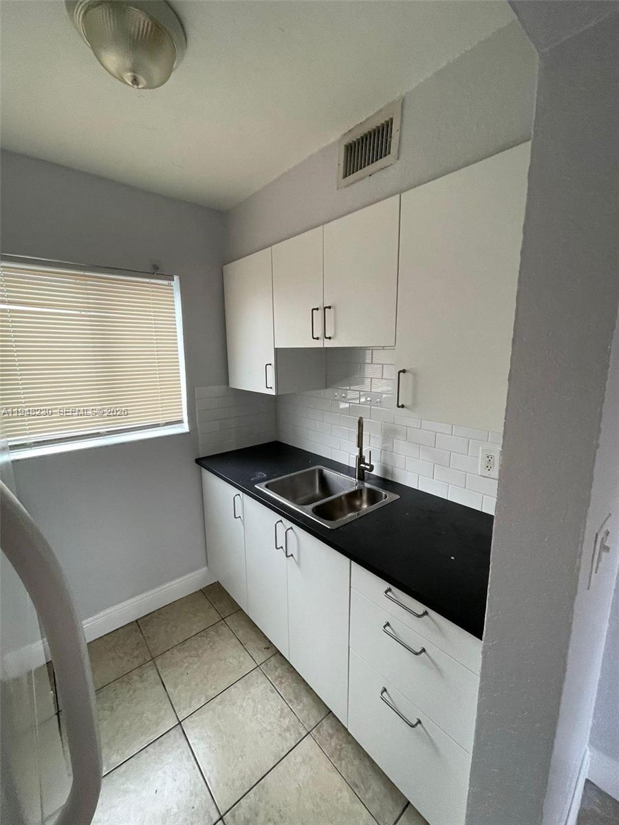 2330 Northwest 11th Street, Unit 9 Miami, FL 33125 - Photo 3 of 18 a kitchen with granite countertop a stove a sink and a refrigerator