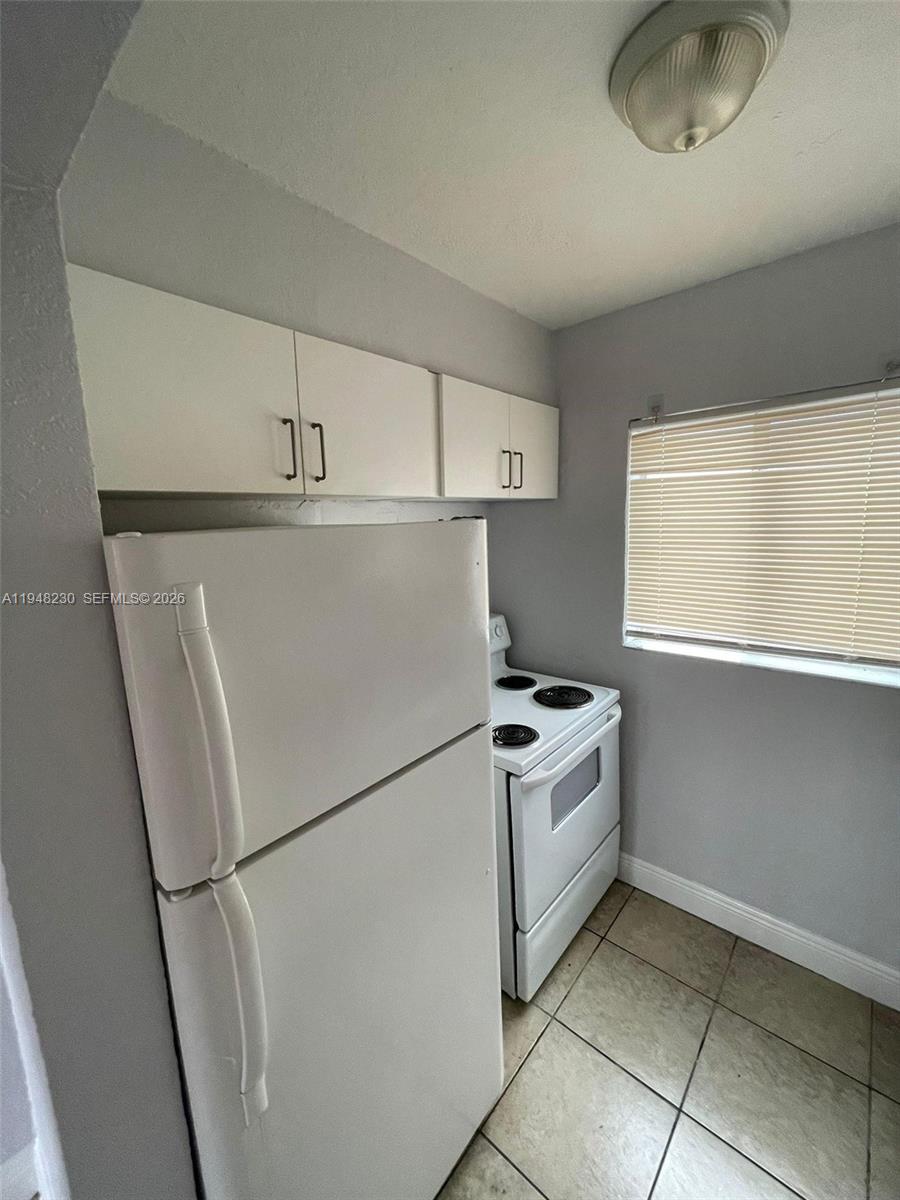2330 Northwest 11th Street, Unit 9 Miami, FL 33125 - Photo 4 of 18 a white refrigerator freezer and a stove sitting inside of a kitchen