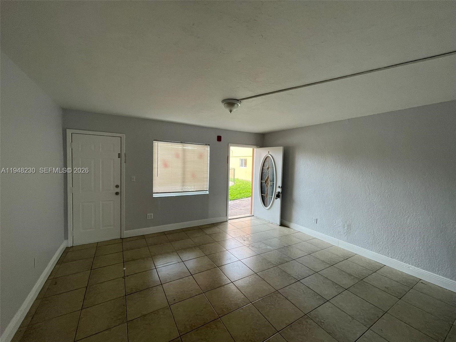 2330 Northwest 11th Street, Unit 9 Miami, FL 33125 - Photo 5 of 18 a view of hallway with a window and chandelier