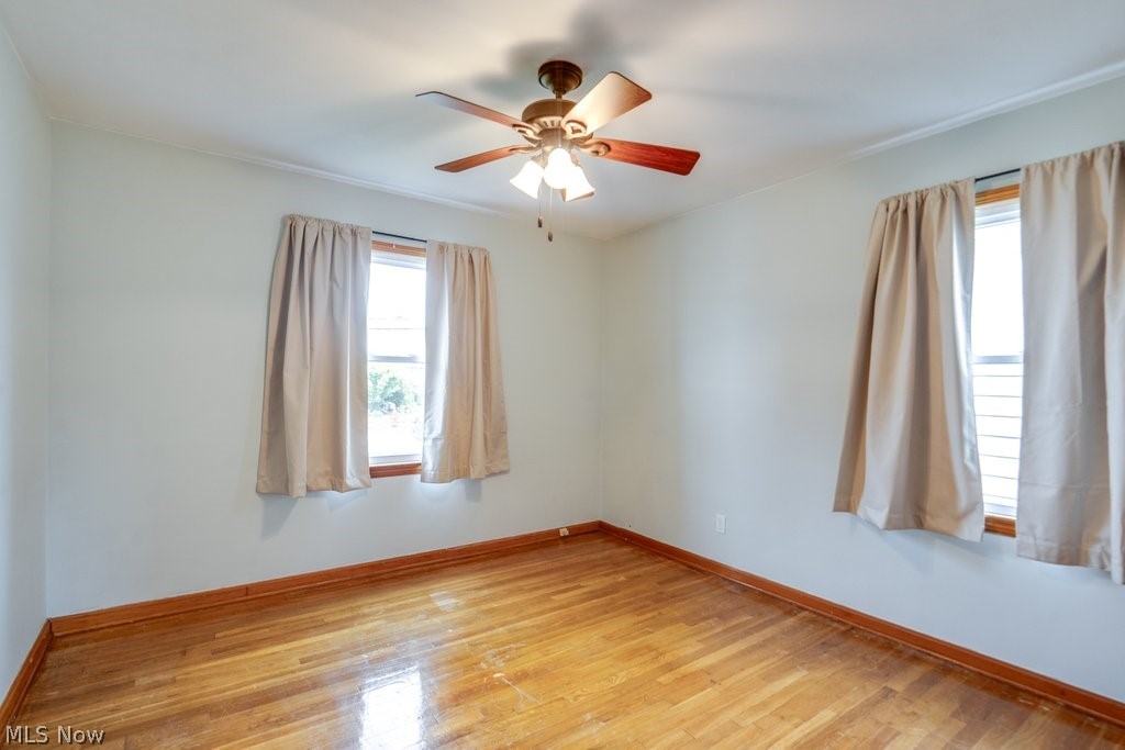 30000 Elgin Road Wickliffe, OH 44092 - Photo 12 of 30 Wood-finish flooring throughout, featuring a ceiling fan with integrated lighting, two windows with wood trim, and crown molding