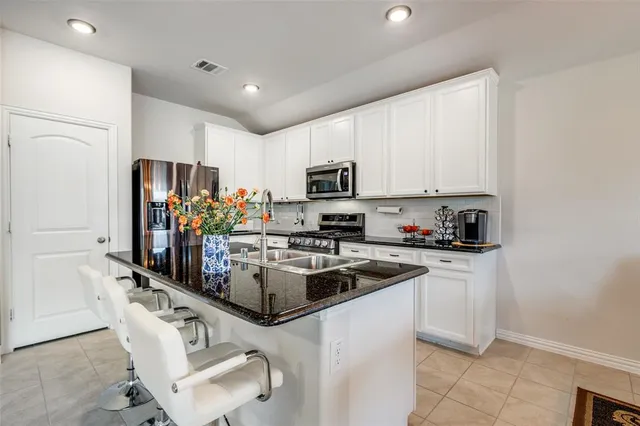 a kitchen with kitchen island granite countertop stainless steel appliances and a sink