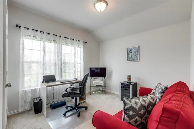 a view of a workspace with furniture and a window