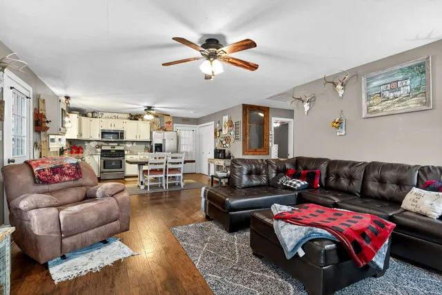 a living room with furniture and view of kitchen