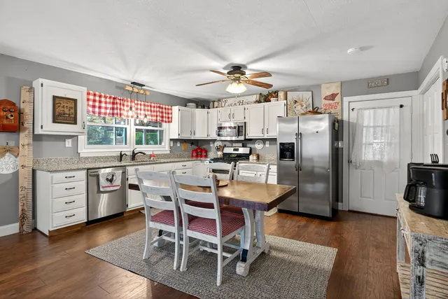 a kitchen with a table chairs refrigerator and cabinets