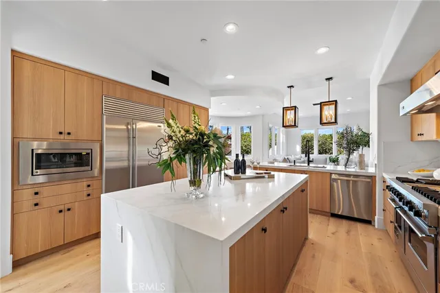 a kitchen with stainless steel appliances granite countertop a sink a stove and a refrigerator