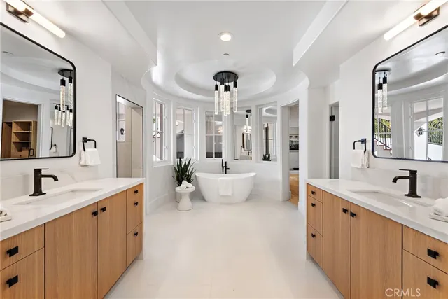 a large bathroom with a double vanity sink mirror and bathtub