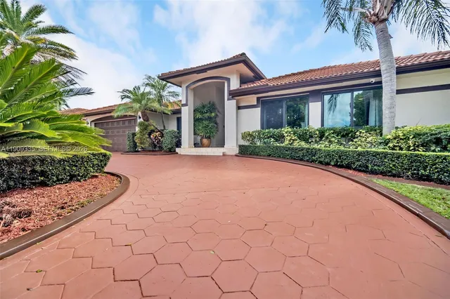 a front view of a house with a garden and plants