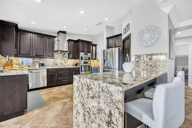 a kitchen with stainless steel appliances a refrigerator and a stove top oven