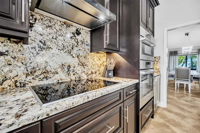 a large kitchen with stainless steel appliances and a stove top oven