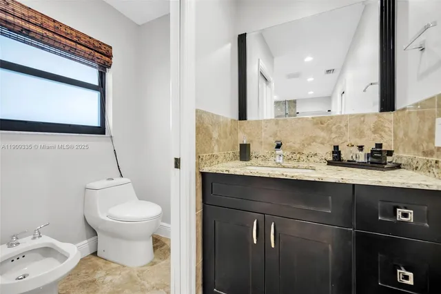 a bathroom with a granite countertop sink a mirror and shower