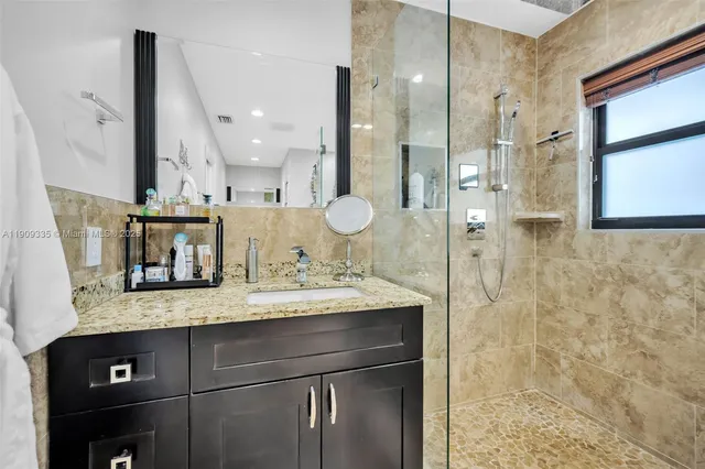 a bathroom with a granite countertop sink a toilet and shower