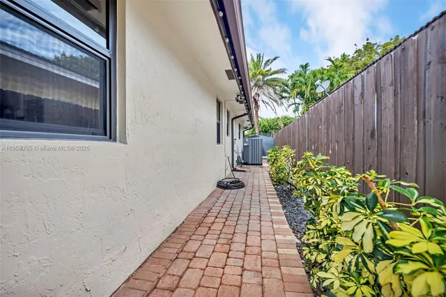 a view of swimming pool in the backyard of house along with seating space and trees