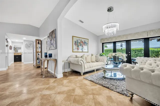 a view of a dining room with furniture a livingroom and chandelier