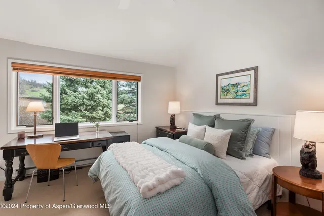 a bedroom with a bed and a large window