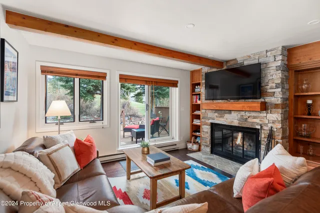 a living room with furniture a flat screen tv and a fireplace