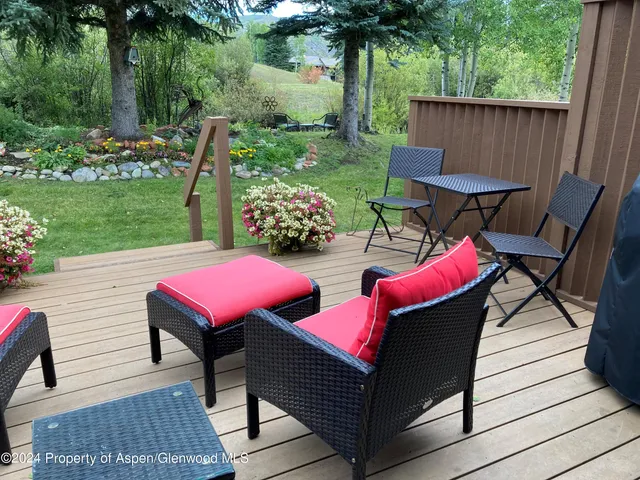 a view of a patio with table and chairs with wooden floor and fence