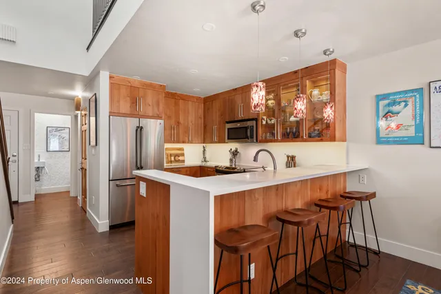 a kitchen with stainless steel appliances a table and chairs