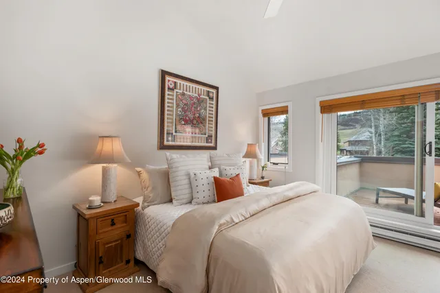 a bedroom with a large bed and a lamp on dresser