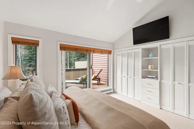 a bed room with a bed a television and a window