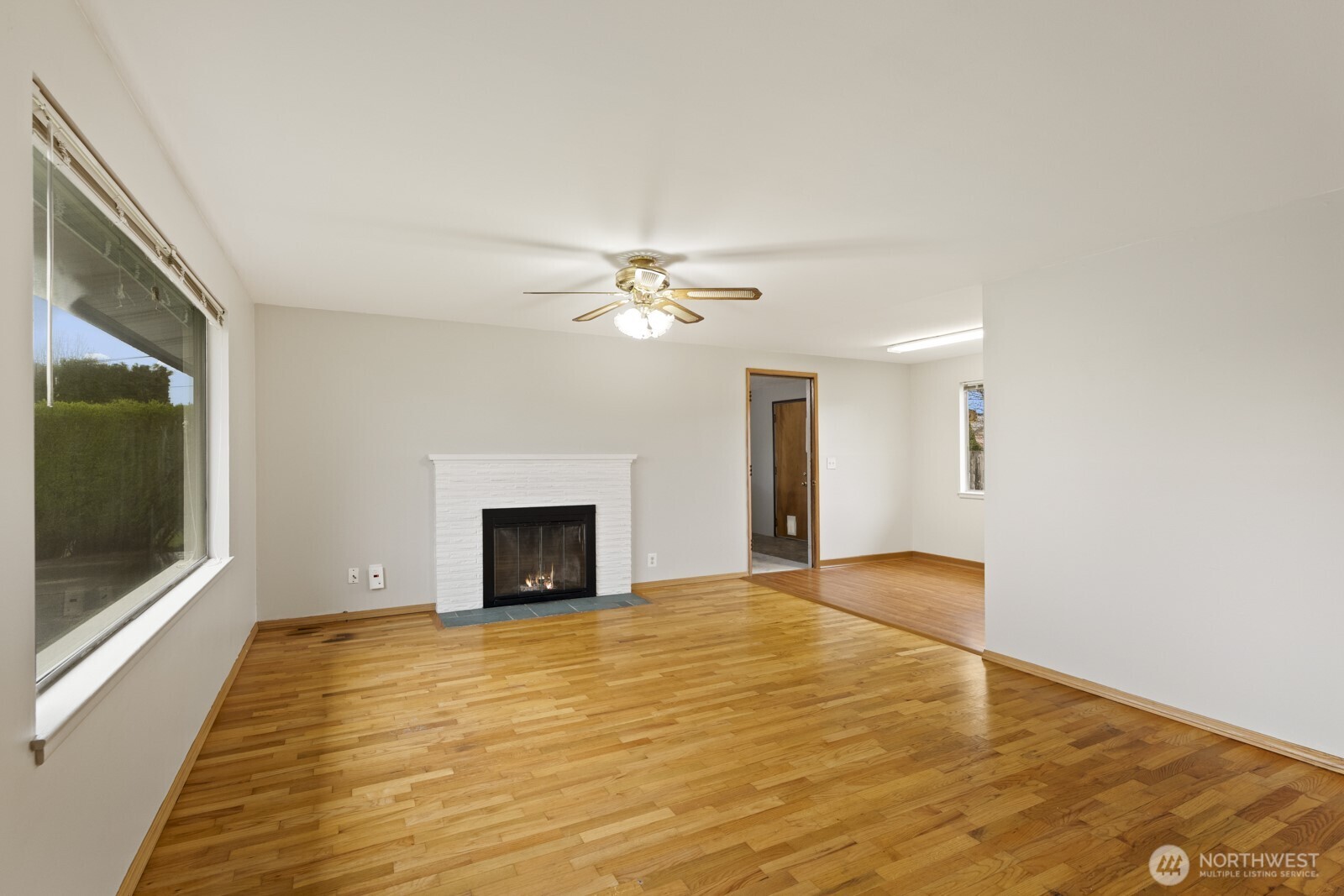 12742 Southeast 171st Place Renton, WA 98058 - Photo 12 of 33 a view of an empty room with a fireplace and a chandelier fan