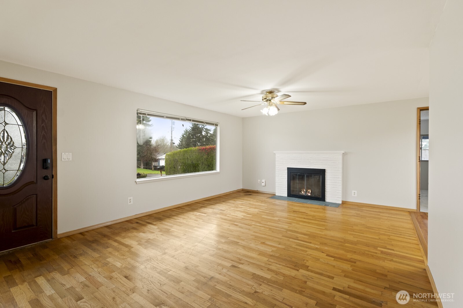 12742 Southeast 171st Place Renton, WA 98058 - Photo 13 of 33 a view of an empty room with chandelier fan and wooden floor