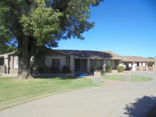 a front view of a house with a yard and trees