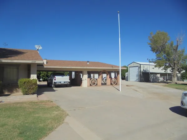 a view of a house with a patio and a yard