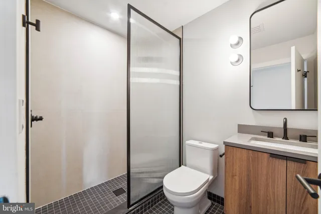 a bathroom with a granite countertop toilet sink and shower