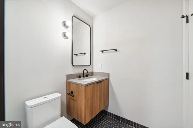 a bathroom with a toilet a sink and mirror