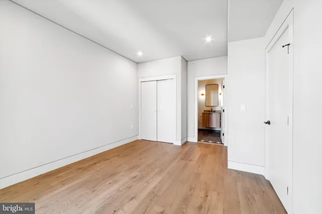 a view of a big room with wooden floor and a bathroom