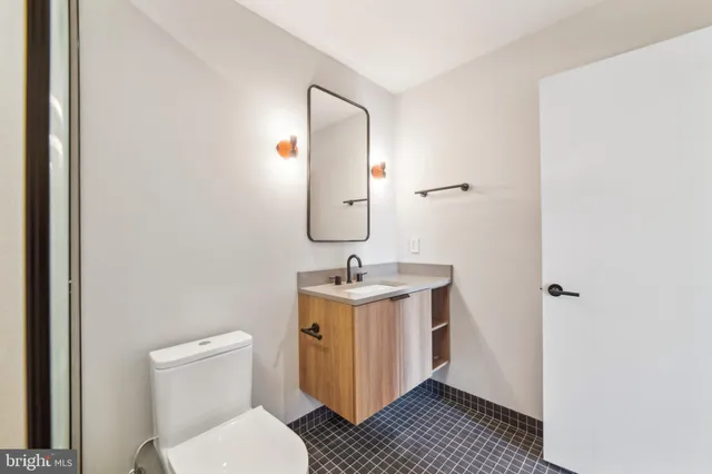 a bathroom with a toilet a sink and mirror