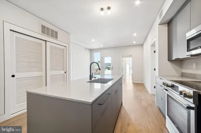 a kitchen with kitchen island a sink stove and refrigerator