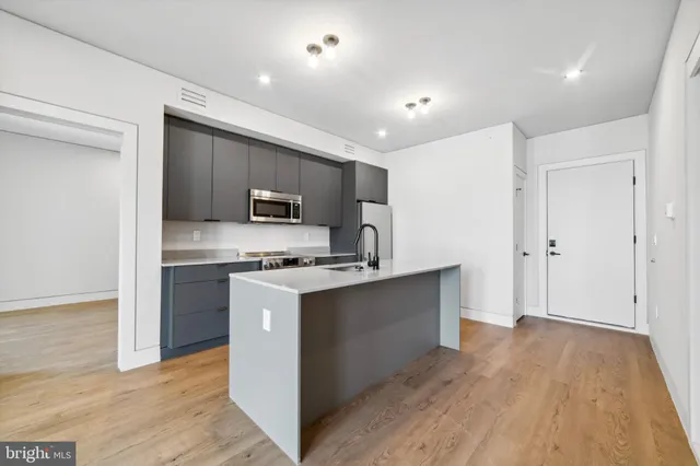 a kitchen with stainless steel appliances granite countertop a refrigerator a stove top oven a sink and dishwasher