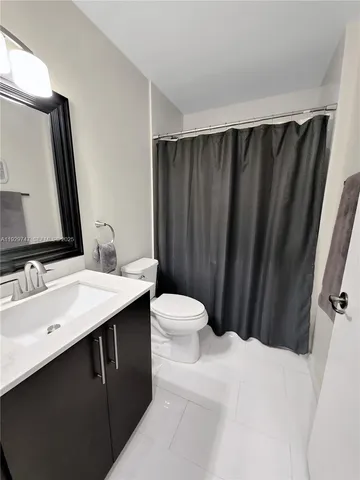 a bathroom with a sink vanity mirror and toilet