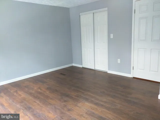 a view of an empty room with wooden floor