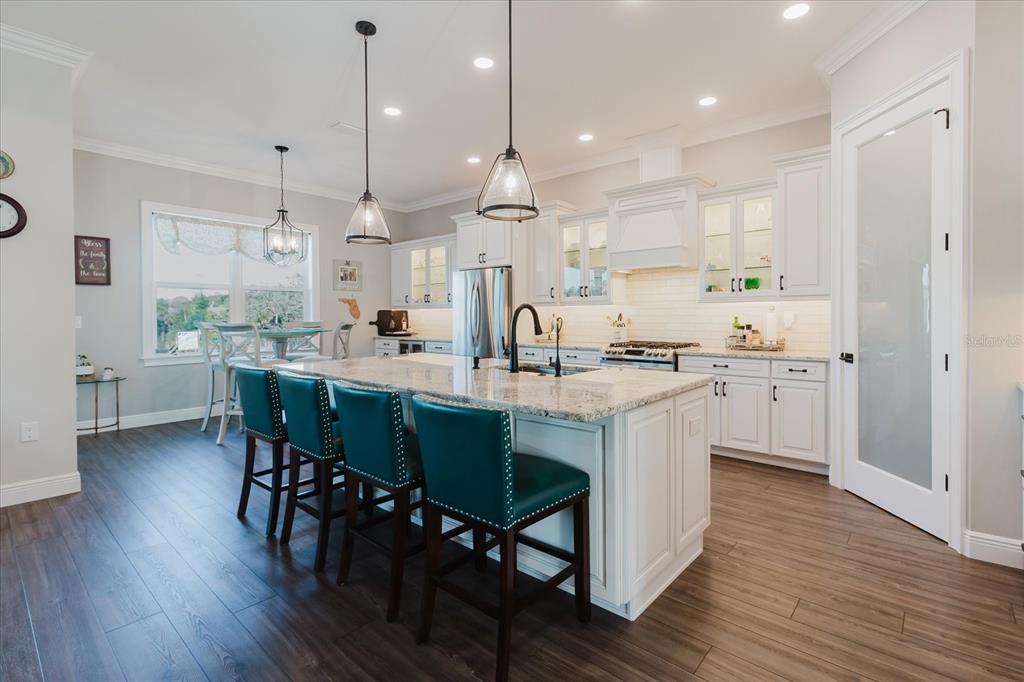 216 High Street Tarpon Springs, FL 34689 - Photo 21 of 75 a kitchen with stainless steel appliances granite countertop wooden floors and white cabinets