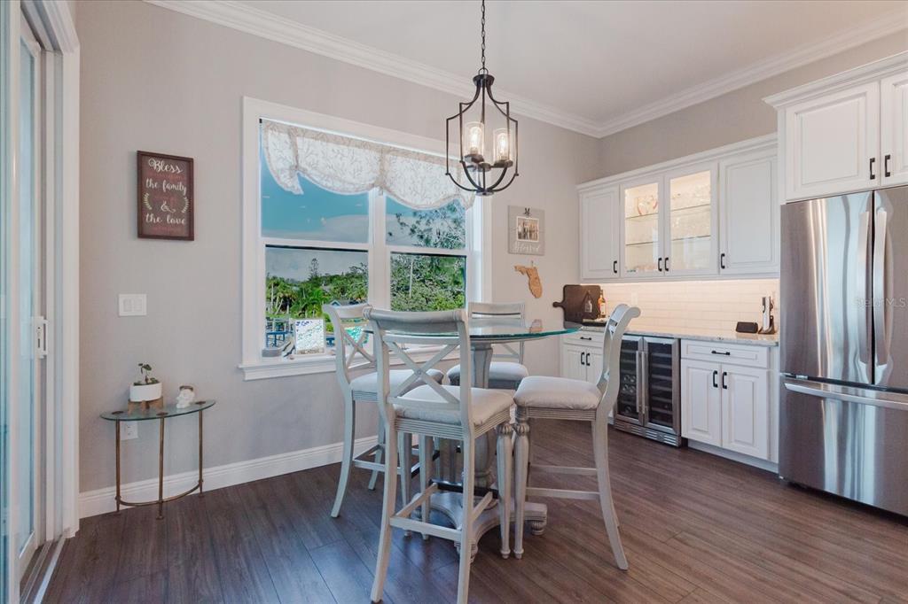 216 High Street Tarpon Springs, FL 34689 - Photo 26 of 75 a dining room with wooden floor a chandelier a glass table and chairs