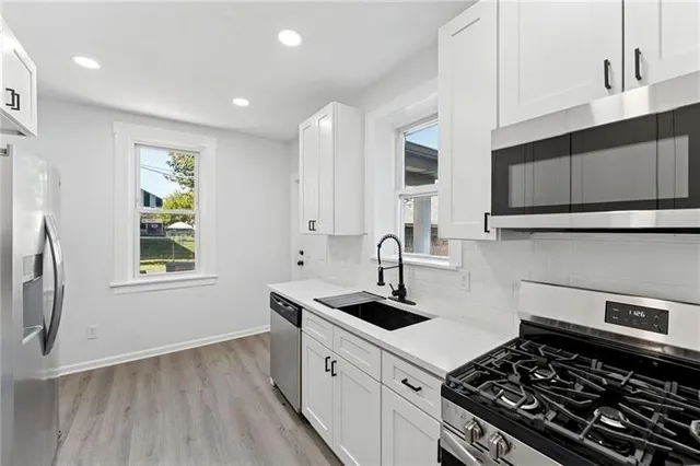 a kitchen with sink a stove and cabinets