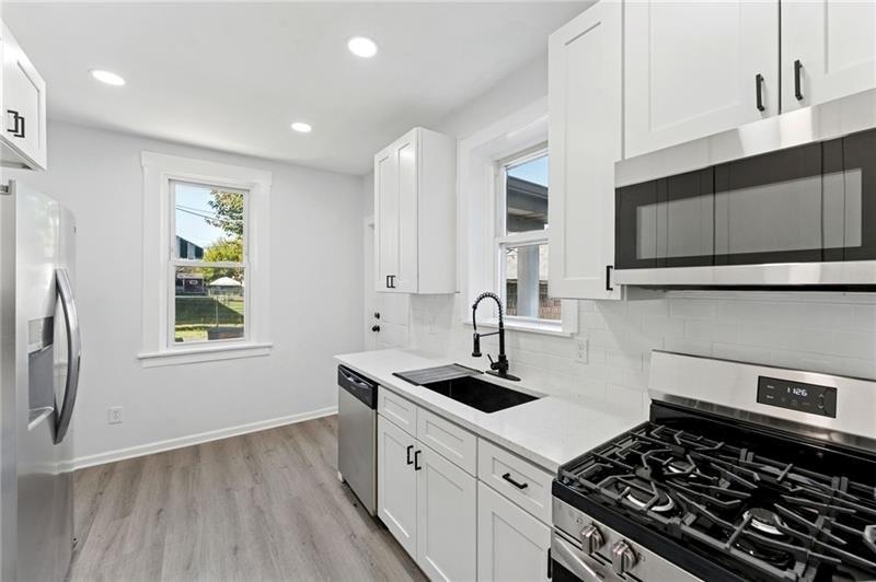 233 East 19th Avenue Homestead, PA 15120 - Photo 11 of 27 a kitchen with sink a stove and cabinets